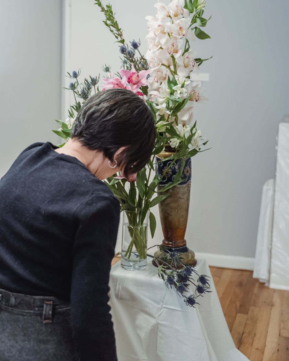 Florista armando un arreglo alto de flores de temporada